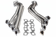 Two metal exhaust manifolds with gaskets on a white background