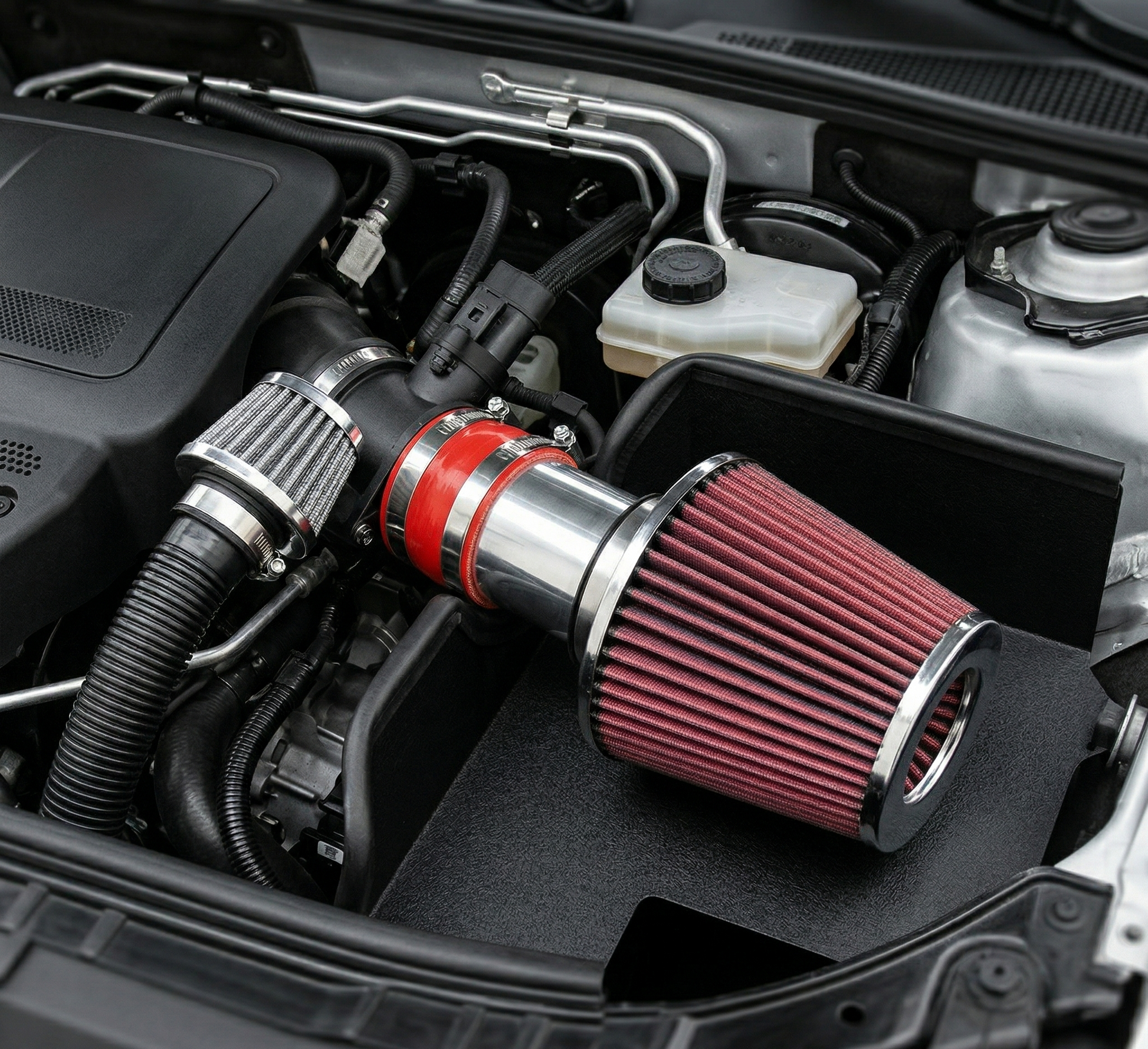 Car air filter with red and silver design installed in a vehicle engine bay.