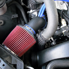 Close-up of a car engine with a red air filter and various hoses.