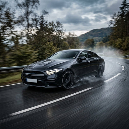 Black Mercedes CLS driving fast on a wet road