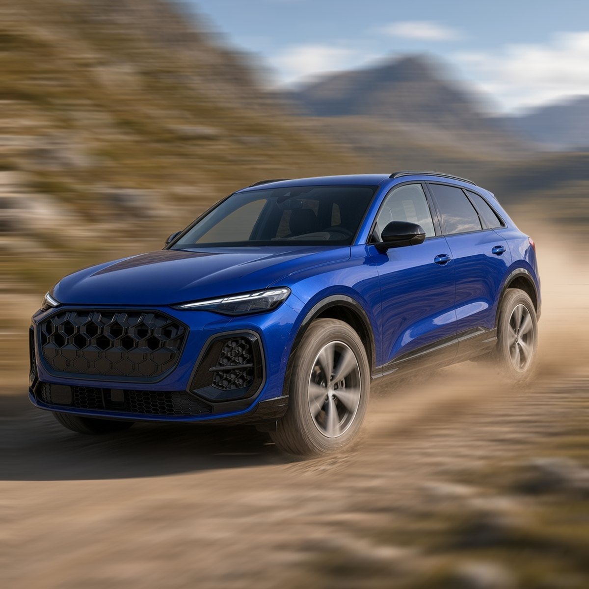 Blue Audi Q5 SUV with off-road wheels driving fast on a gravel track