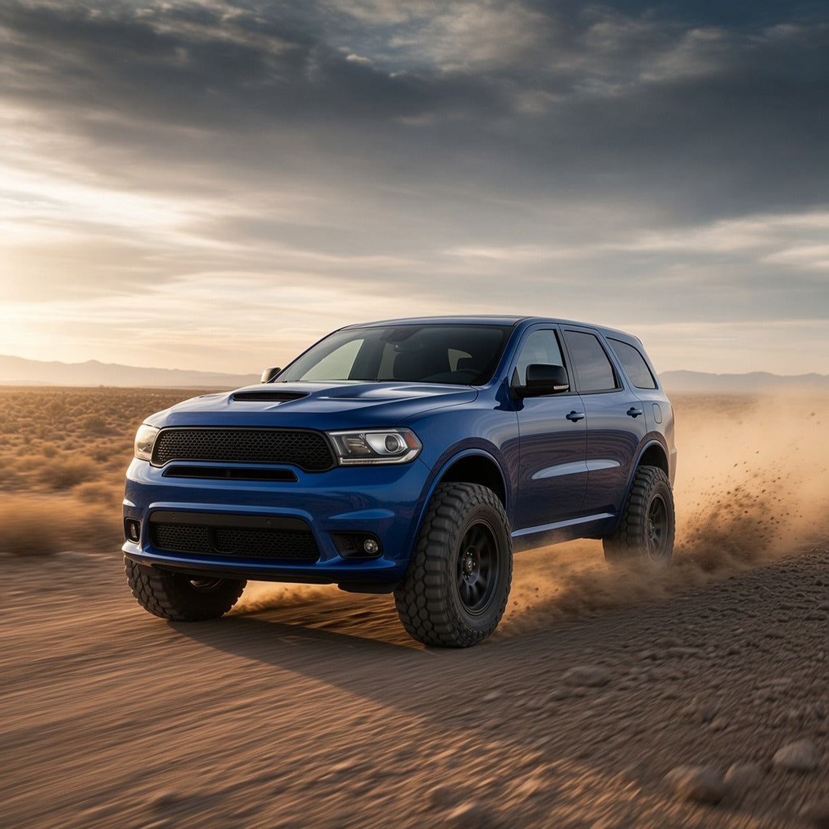 Blue 2014-2019 Dodge Durango with off-road wheels and all-terrain tires kicking up dust on a desert trail