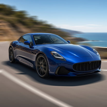 Blue Maserati GranTurismo with large aftermarket wheels driving fast