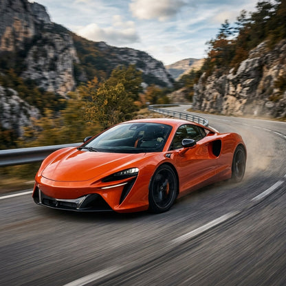 Orange McLaren Artura driving fast on a mountain road