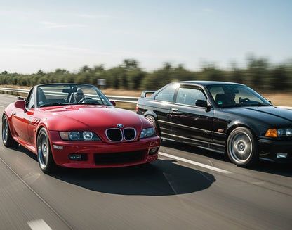 Red BMW Z3 roadster and black BMW E36 coupe driving fast
