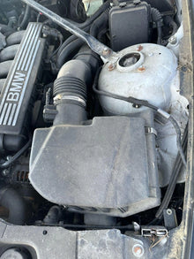 Car engine with visible BMW branding on a mechanical component.