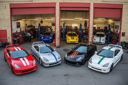 Four Toyota Celica GT coupes parked outside a workshop